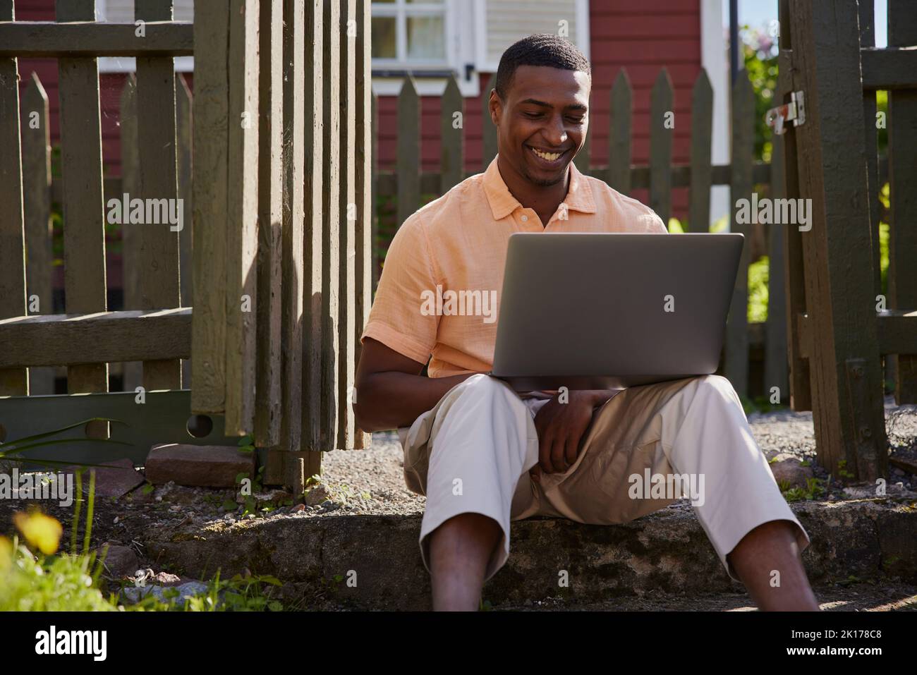 Homme avec ordinateur portable en face de la maison en bois Banque D'Images