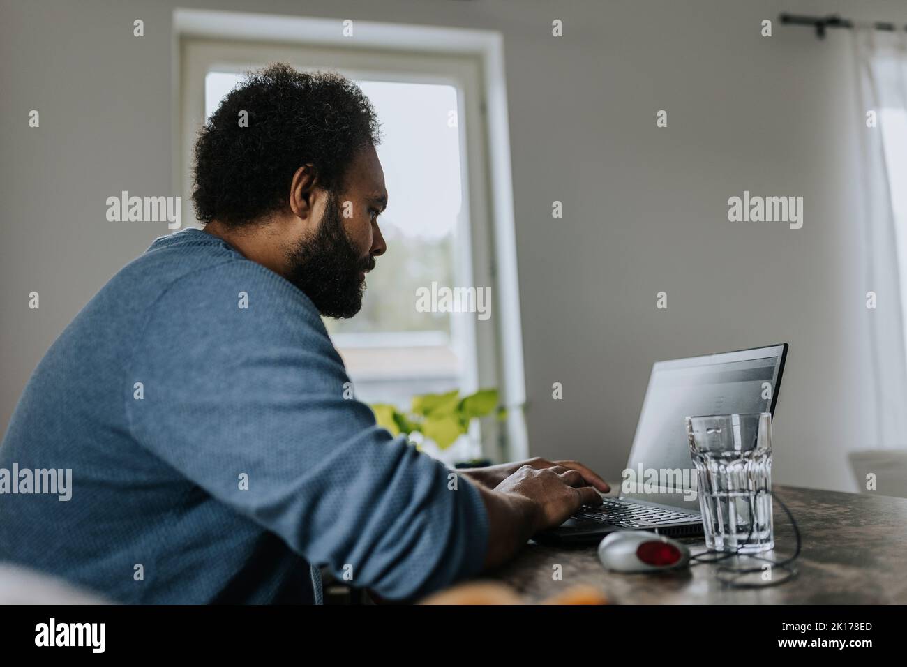 Homme travaillant sur un ordinateur portable de la maison Banque D'Images