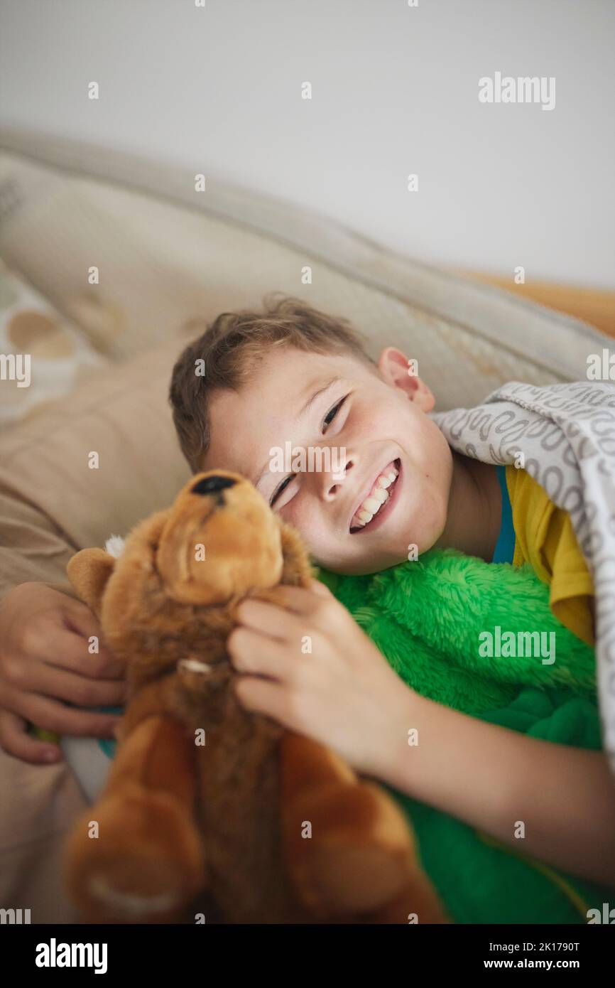 Portrait d'un garçon souriant tenant un jouet en peluche Banque D'Images
