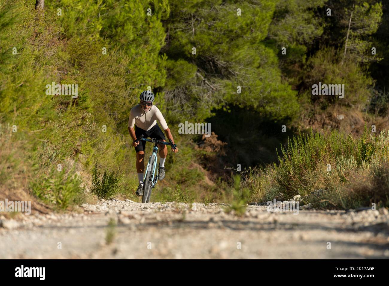 Un cycliste dans une route de gravier à vélo dans les montagnes de la Costa Blanca, Alicante, Espagne Banque D'Images