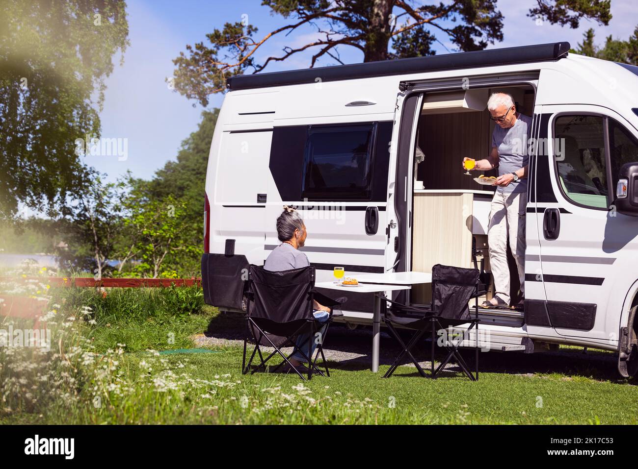 Couple senior prenant un repas en camping-car Banque D'Images