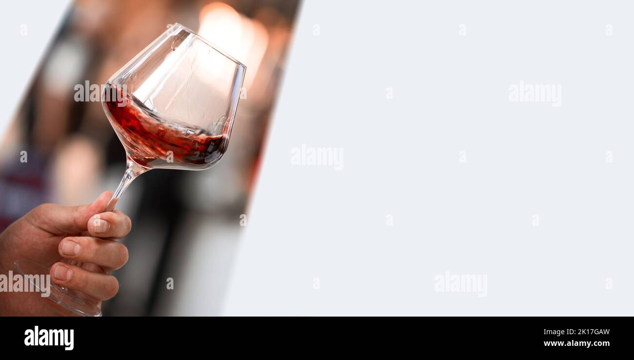 Verre de vin rouge à la main sur la dégustation de boissons alcoolisées image pour bannières, poster, magazine, Flayer, maquette. Banque D'Images