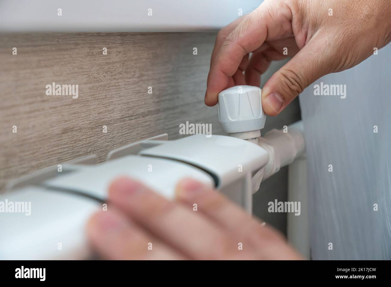 homme touchant à peine la batterie chaude pendant la saison de chauffage. Appareils de chauffage dans la maison, vue latérale. Inconfort du froid. Réglage de la chaleur et de la tempera Banque D'Images