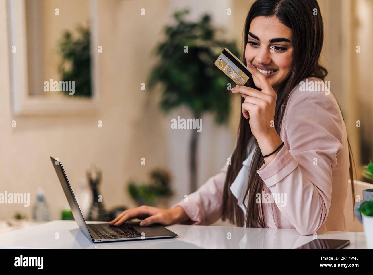 Belle jeune femme brune, en vérifiant son compte bancaire en ligne, de son bureau de compagnie. Banque D'Images