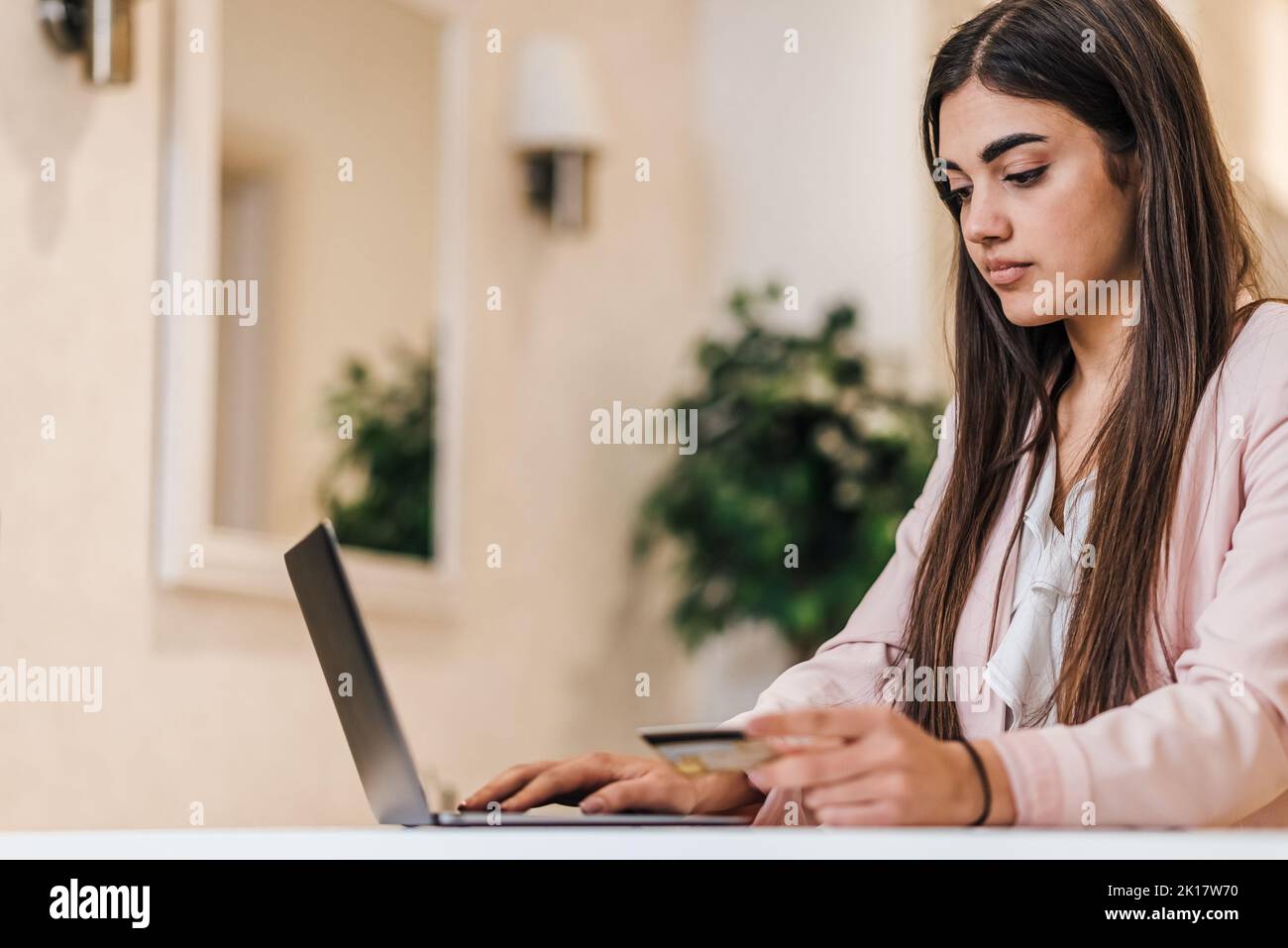 Jeune femme élégante concentrée, en vérifiant sa note de crédit, tout en travaillant au bureau. Banque D'Images