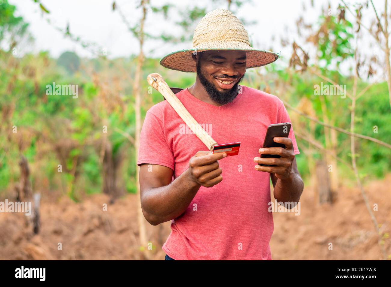 agriculteur africain utilisant son téléphone et sa carte de crédit Banque D'Images