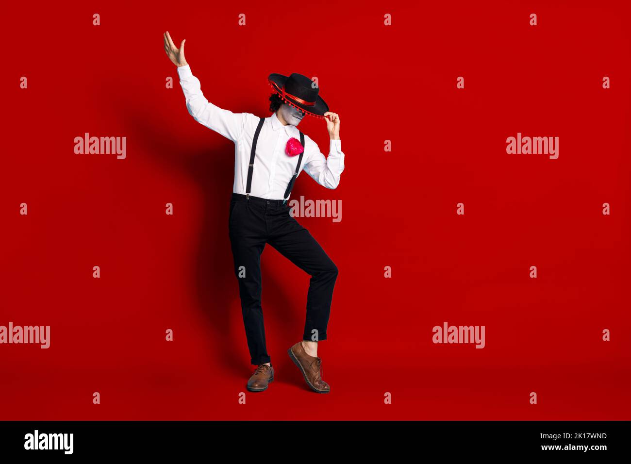 Vue sur toute la longueur du corps de son skinny mystérieux grand homme étranger danse avoir plaisir cacher le visage derrière sombrero culte rituel isolé Banque D'Images