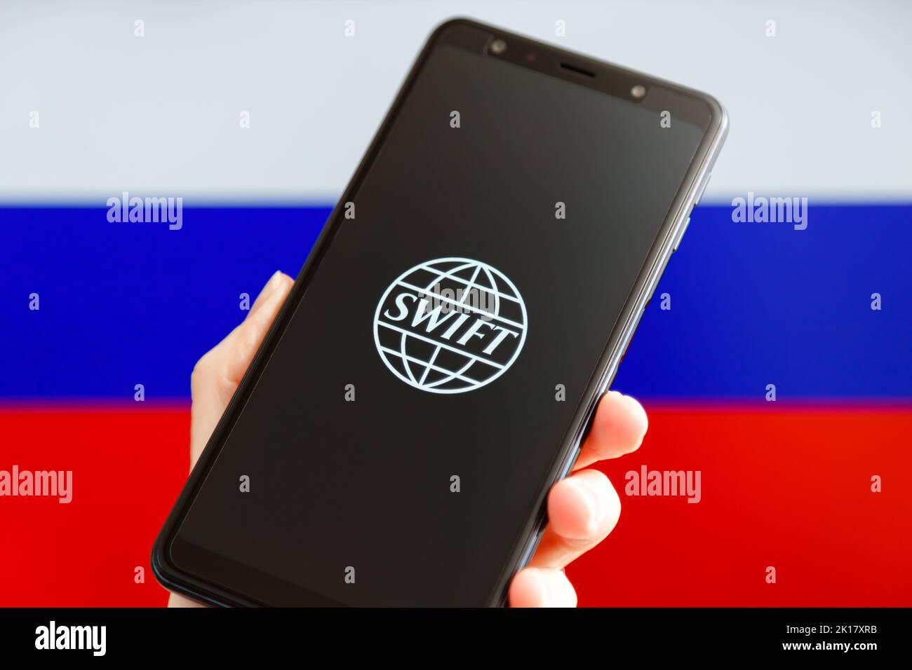 Ukraine, Kiev - février 23 2022 : portable avec logo SWIFT et drapeau russe en arrière-plan. Sanctions contre la Russie, déconnexion du concept SWIFT. Banque D'Images