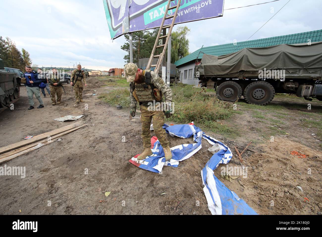 IZIUM, UKRAINE - le 15 SEPTEMBRE 2022 - Un militaire ukrainien a piétiné sur une bannière de propagande russe à Izium qui a été libérée de russe dans Banque D'Images