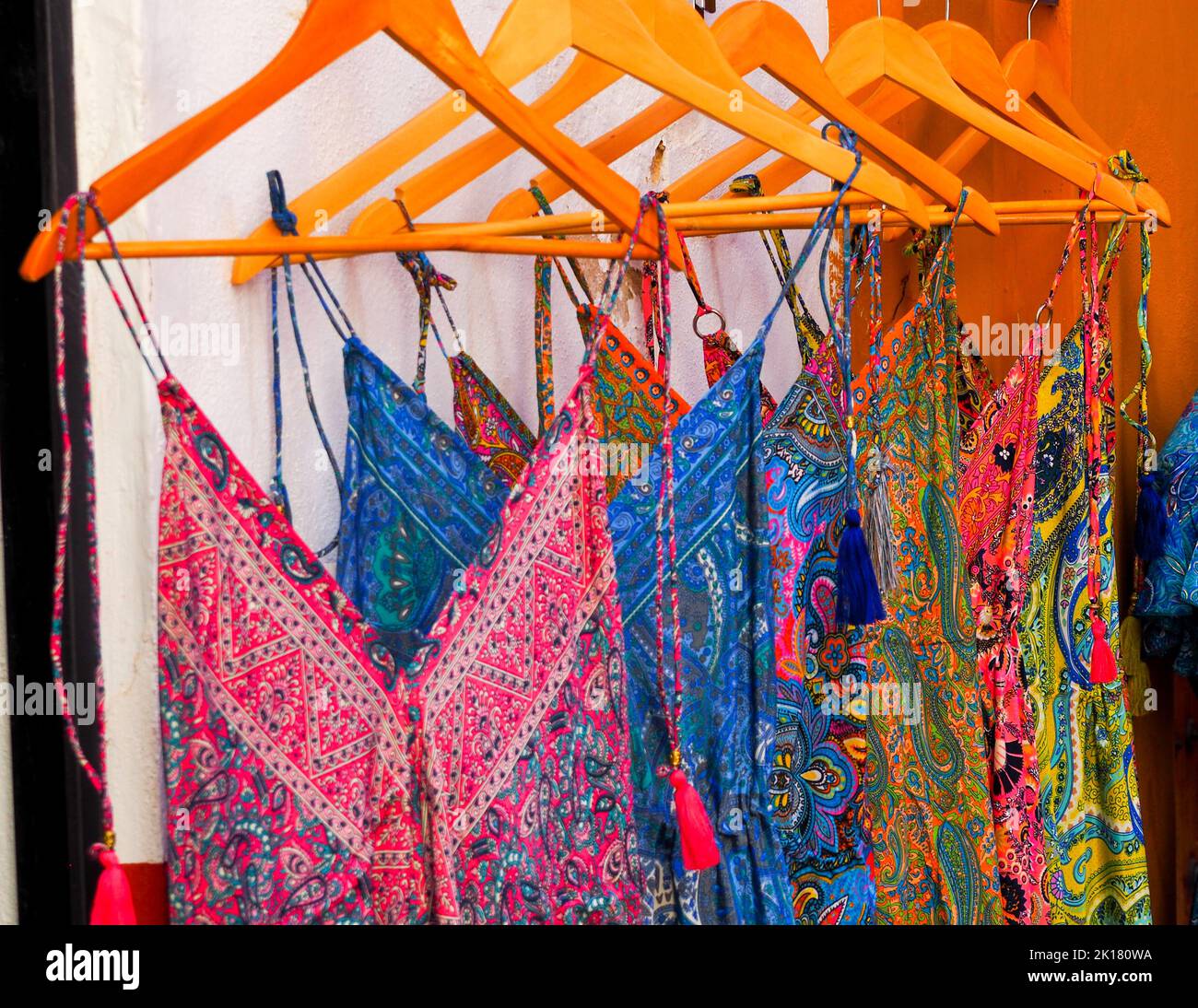 Ensemble de belles robes pour femmes de différentes couleurs affichées sur des cintres à vendre dans la rue Banque D'Images