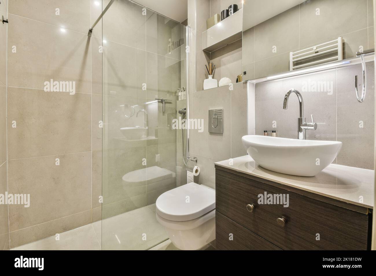 Cloison en verre entre le robinet de douche et les toilettes murales dans les toilettes modernes de la maison Banque D'Images
