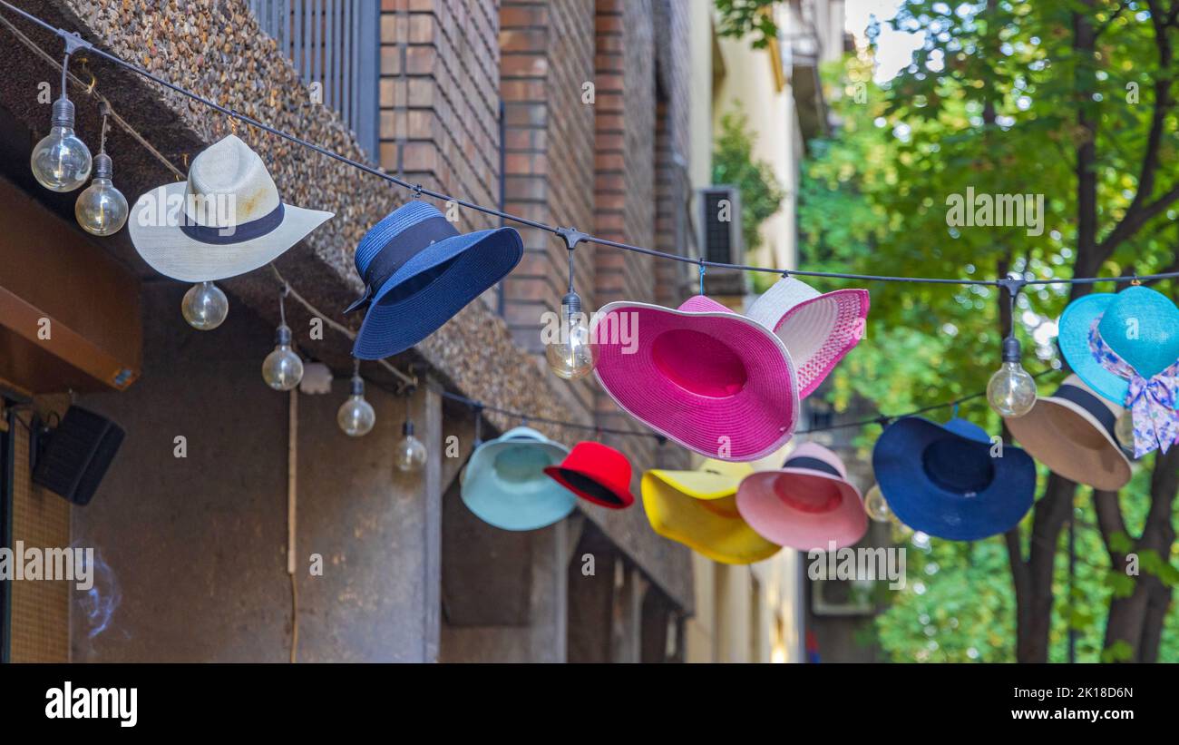 Des chapeaux modernes et colorés sont suspendus au décor de la rue l'été Banque D'Images