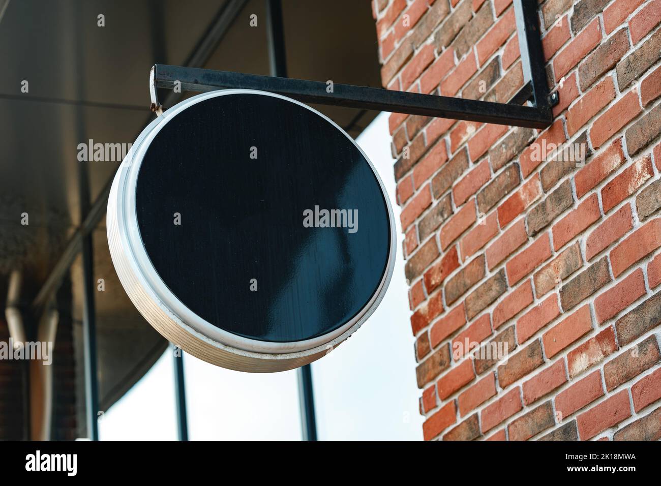 Vider le panneau rond noir sur le mur de briques Banque D'Images