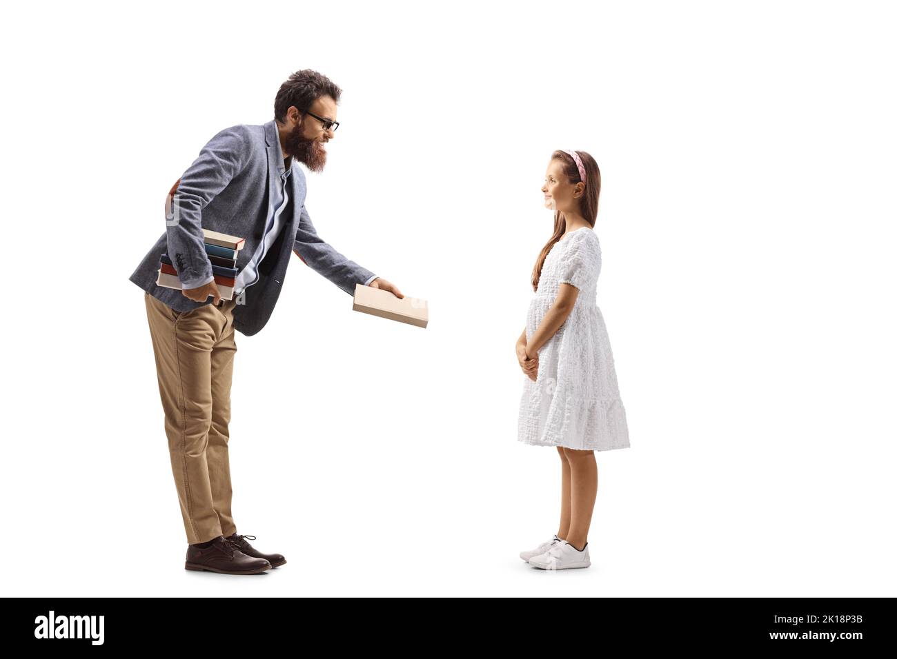 De toute la longueur un enseignant de donner un livre à une fille isolé sur fond blanc Banque D'Images