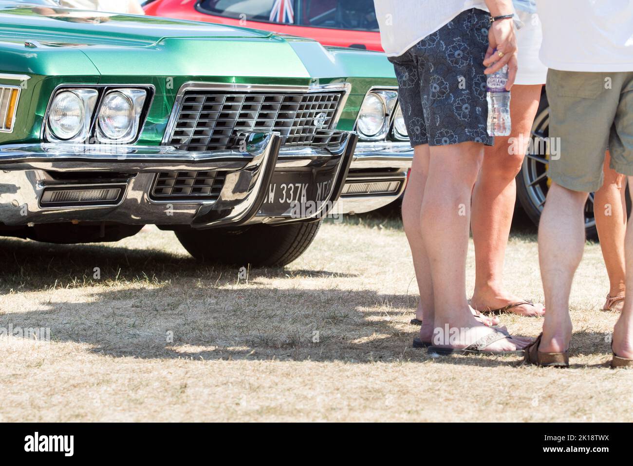 Vue sur les jambes des passionnés de voiture lorsqu'ils se tiennent debout et parlent pendant une journée d'été au salon de voiture classique de Saffron Walden, Essex, Royaume-Uni Banque D'Images