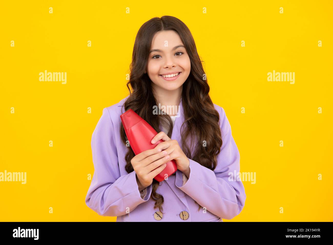 Enfant fille de l'adolescence avec des shampooings et gel douche. Soins capillaires longs de l'adolescent. Présentation du produit cosmétique, bouteille de shampooing. Joyeux adolescent Banque D'Images