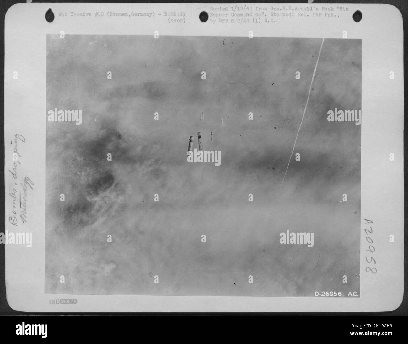 De la fumée s'élevant au-dessus des nuages alors que d'autres bombes sont larguées. Banque D'Images