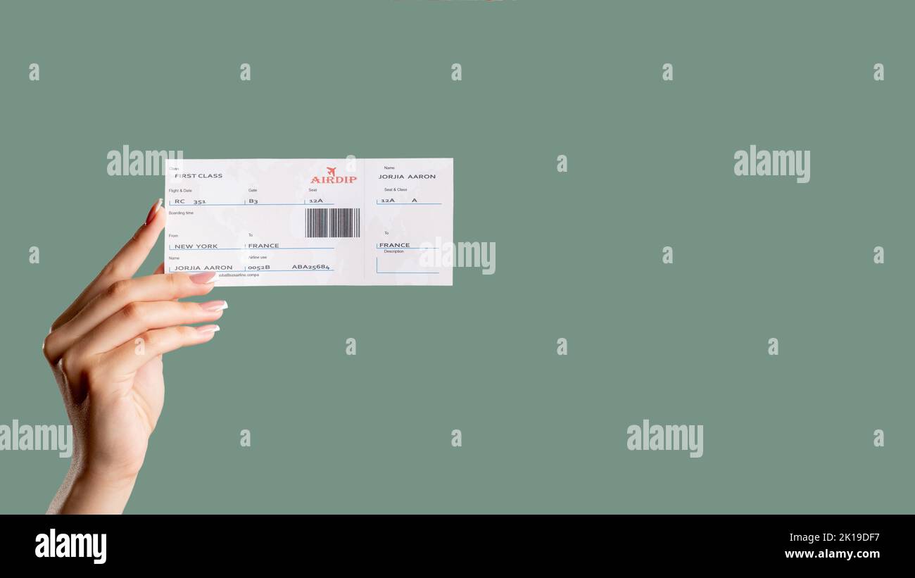 Carte d'embarquement. Voyage international. Une femme tenant un billet de vol de première classe isolée sur un espace vert sauge. Voyages internationaux. Vacati Banque D'Images