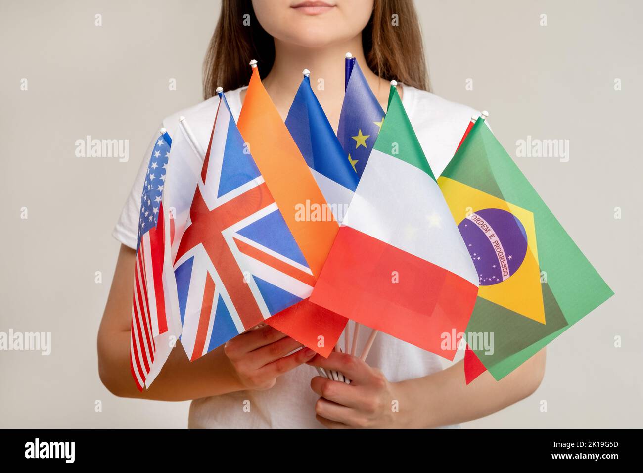 Communauté mondiale. Organisation mondiale. Femme tenant des drapeaux internationaux isolés sur fond de lumière floue. convention politique. Nations Unies. Gover Banque D'Images