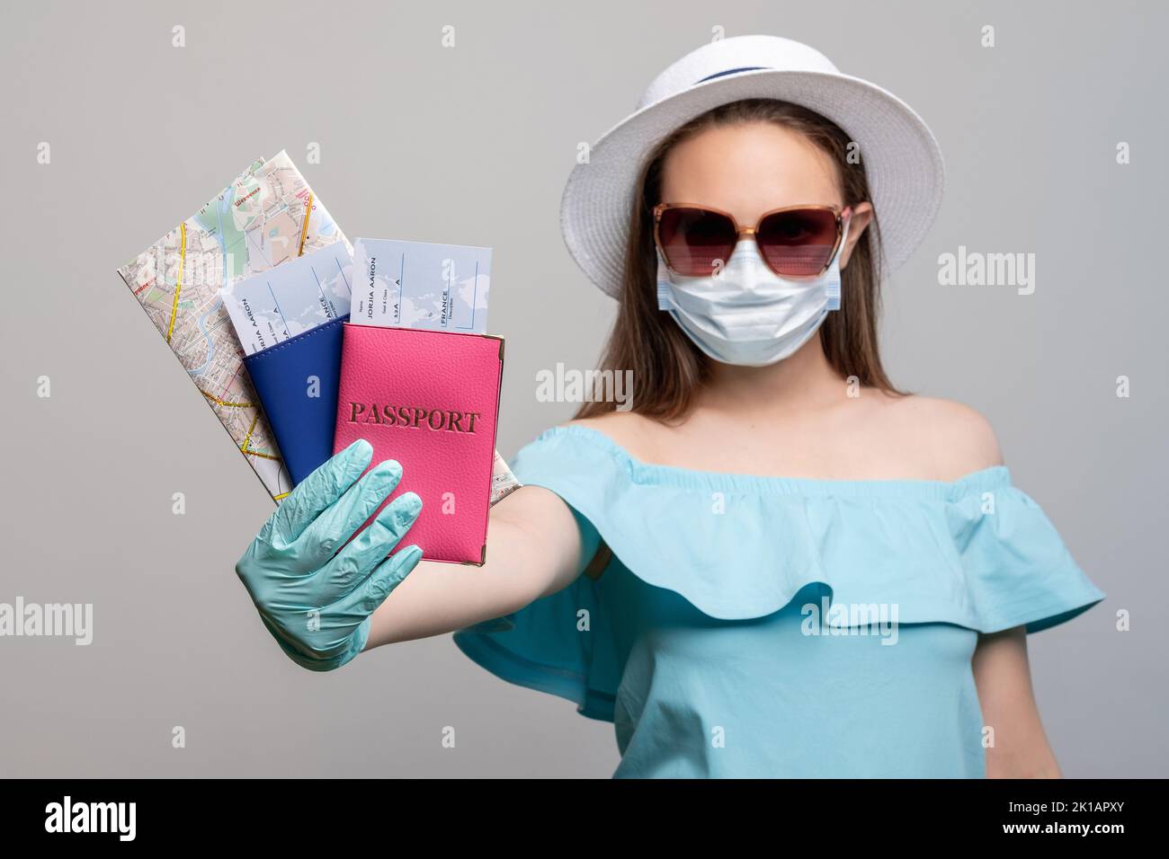 Protection contre les pandémies. Mettre fin à la quarantaine. Femme titulaire de passeports carte des billets. Isolé sur gris. Ouvrir les bordures. Mesures du coronavirus. Visites d'été Banque D'Images