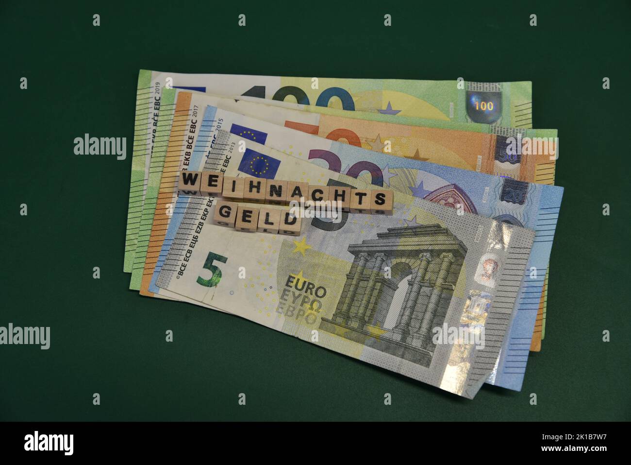 le mot allemand pour le bonus de noël avec des briques de wodden et des billets de banque en euros Banque D'Images