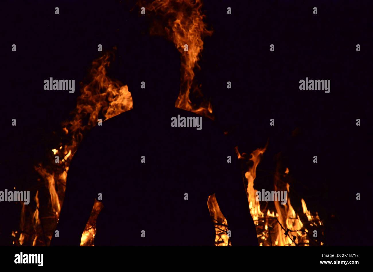 Une silhouette d'un homme vu de derrière en regardant les flammes brûlantes Banque D'Images