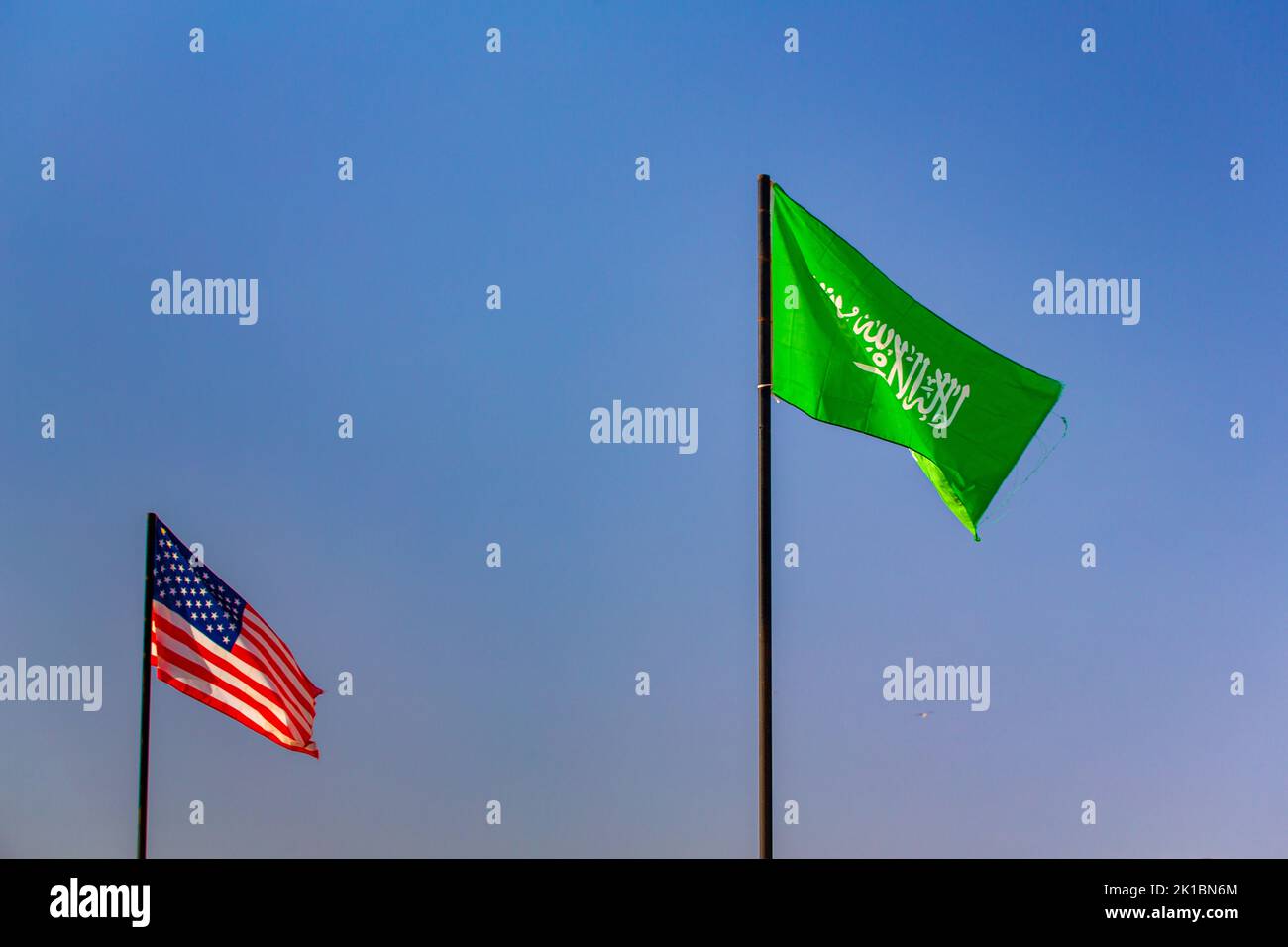 Le drapeau national de l'arabie saoudite et de l'Etat-unis d'amérique agitant dans un ciel bleu Banque D'Images