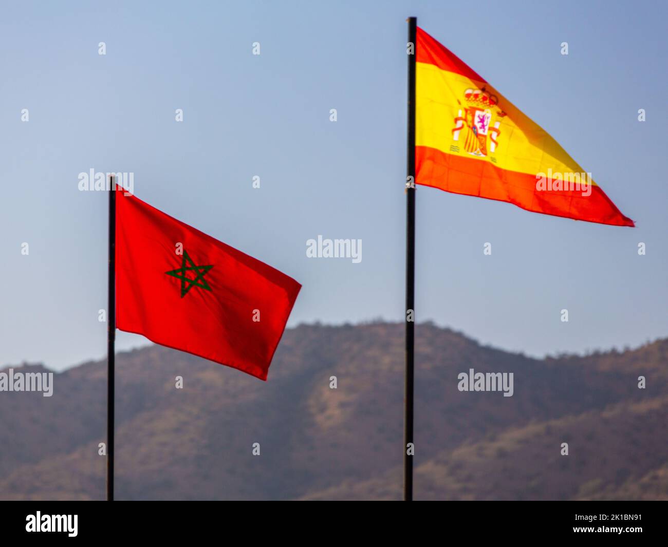 Le drapeau national du maroc et de l'espagne agitant dans un ciel bleu Banque D'Images