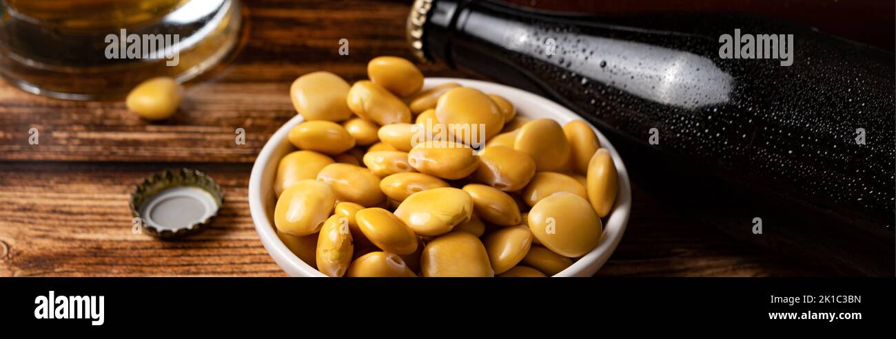 Haricots lupin salés avec bière sur la table Banque D'Images