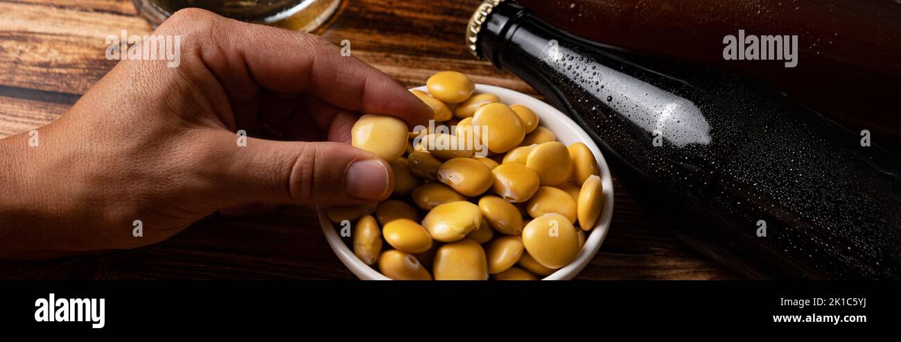 Haricots lupin salés avec bière sur la table Banque D'Images