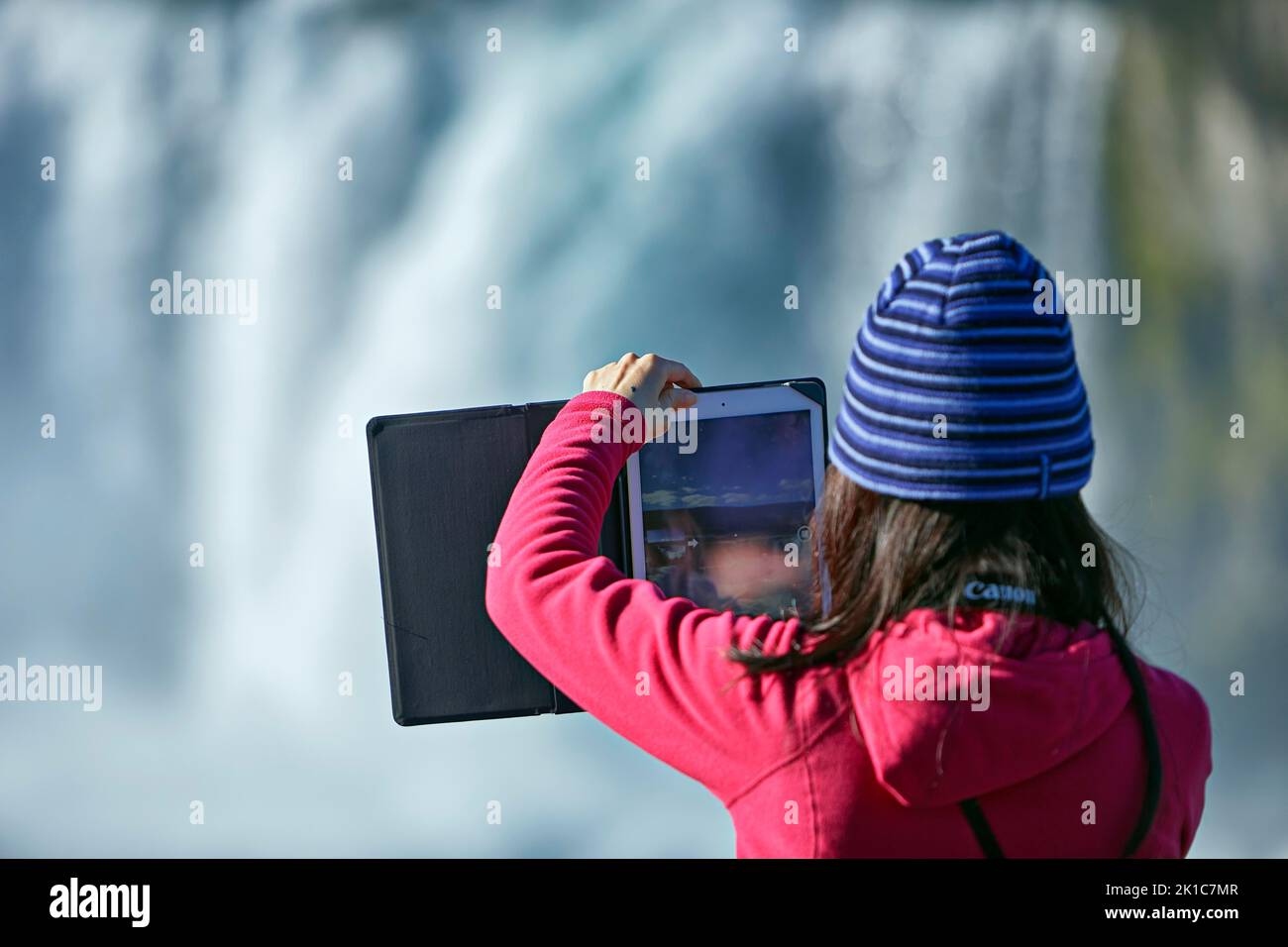 Jeune femme faisant le panorama avec tablette, cascade Godafoss, Laugar, Fossholli, Islande Banque D'Images