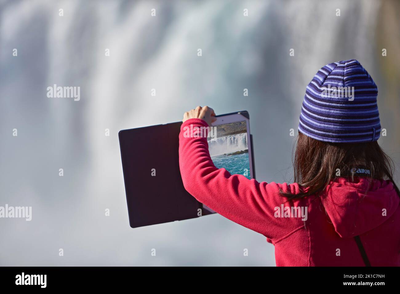 Jeune femme faisant le panorama avec tablette, cascade Godafoss, Laugar, Fossholli, Islande Banque D'Images