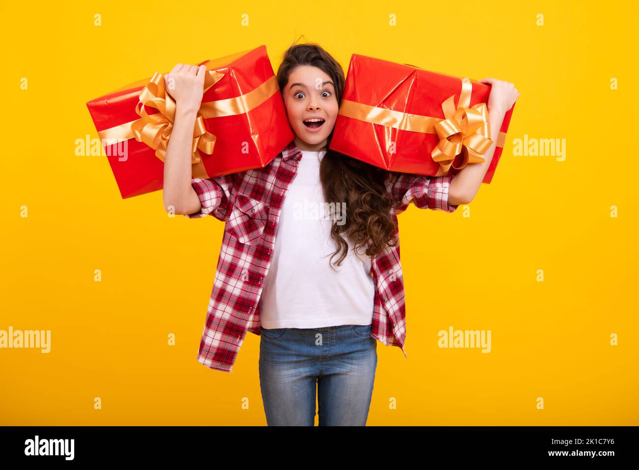 Enfant avec boîte cadeau sur fond isolé. Cadeaux pour l'anniversaire, le jour de la Saint-Valentin, le nouvel an ou Noël. Adolescent heureux, positif et souriant Banque D'Images