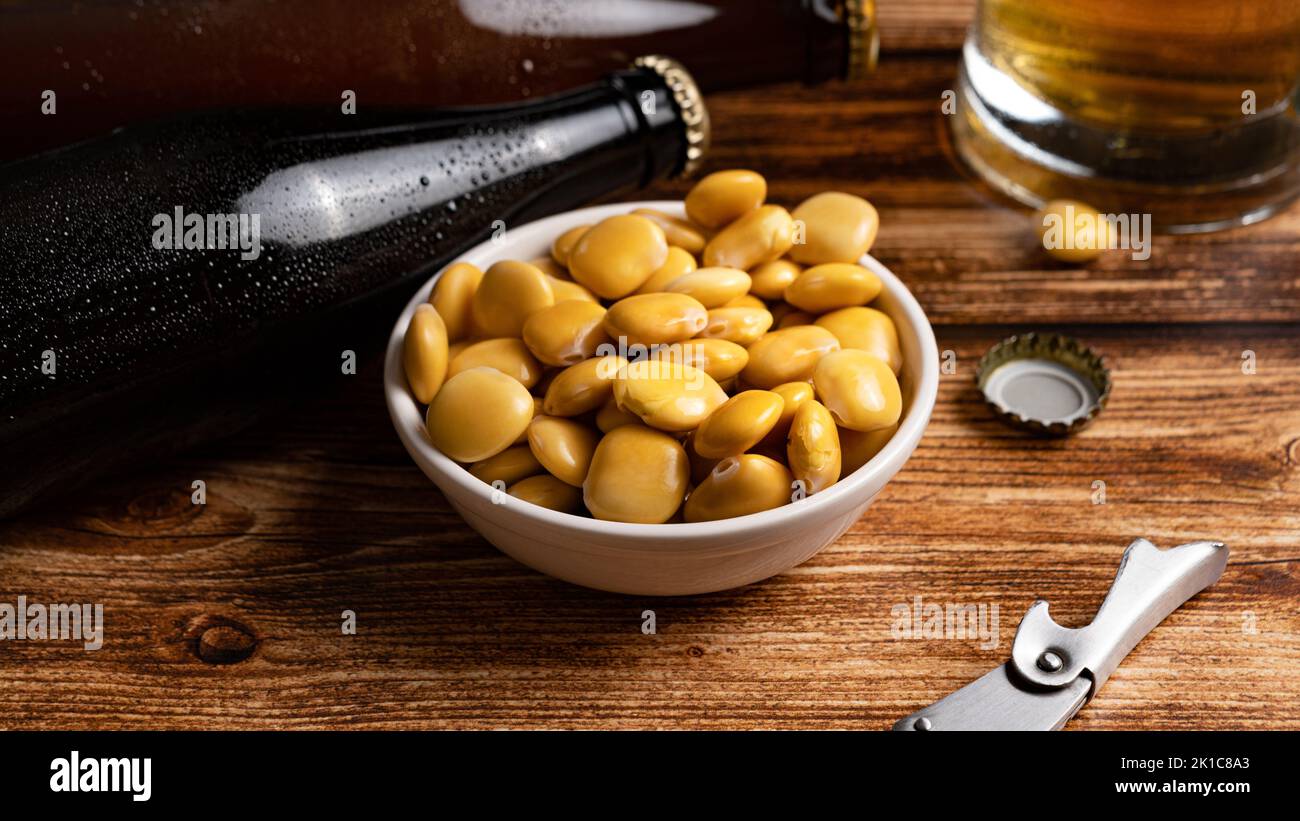 Haricots lupin salés avec bière sur la table Banque D'Images