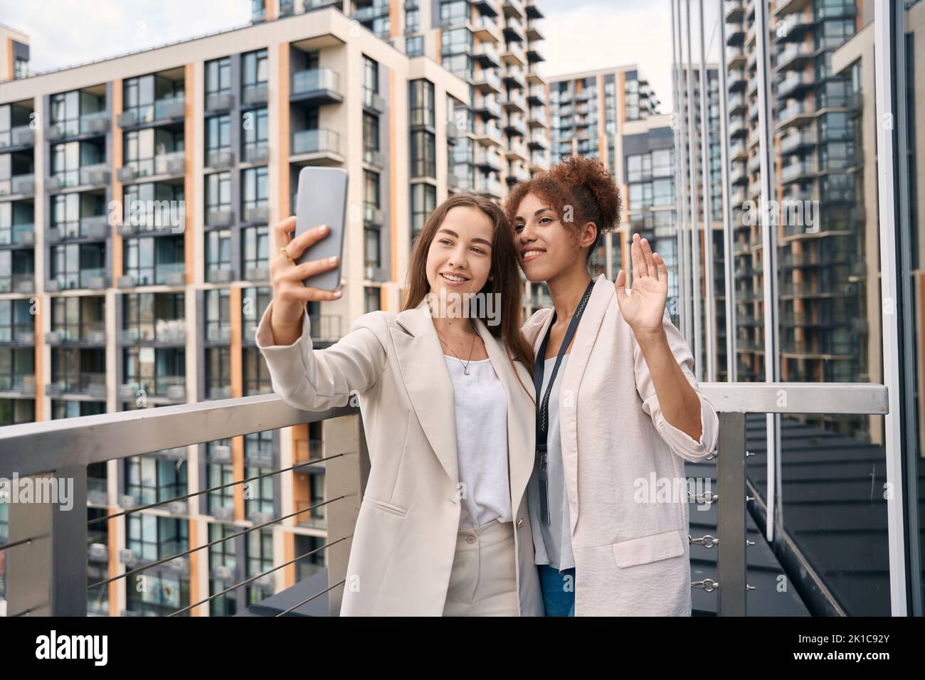 Des femmes d'affaires gaies et stylées qui prennent le selfie à l'extérieur Banque D'Images