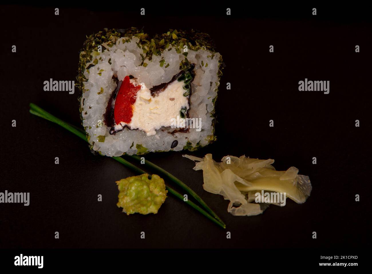 Fromage doux, poivron rouge et rouleau de Californie à ciboulette avec un revêtement en poudre d'algues avec du wasabi et du gingembre mariné Banque D'Images