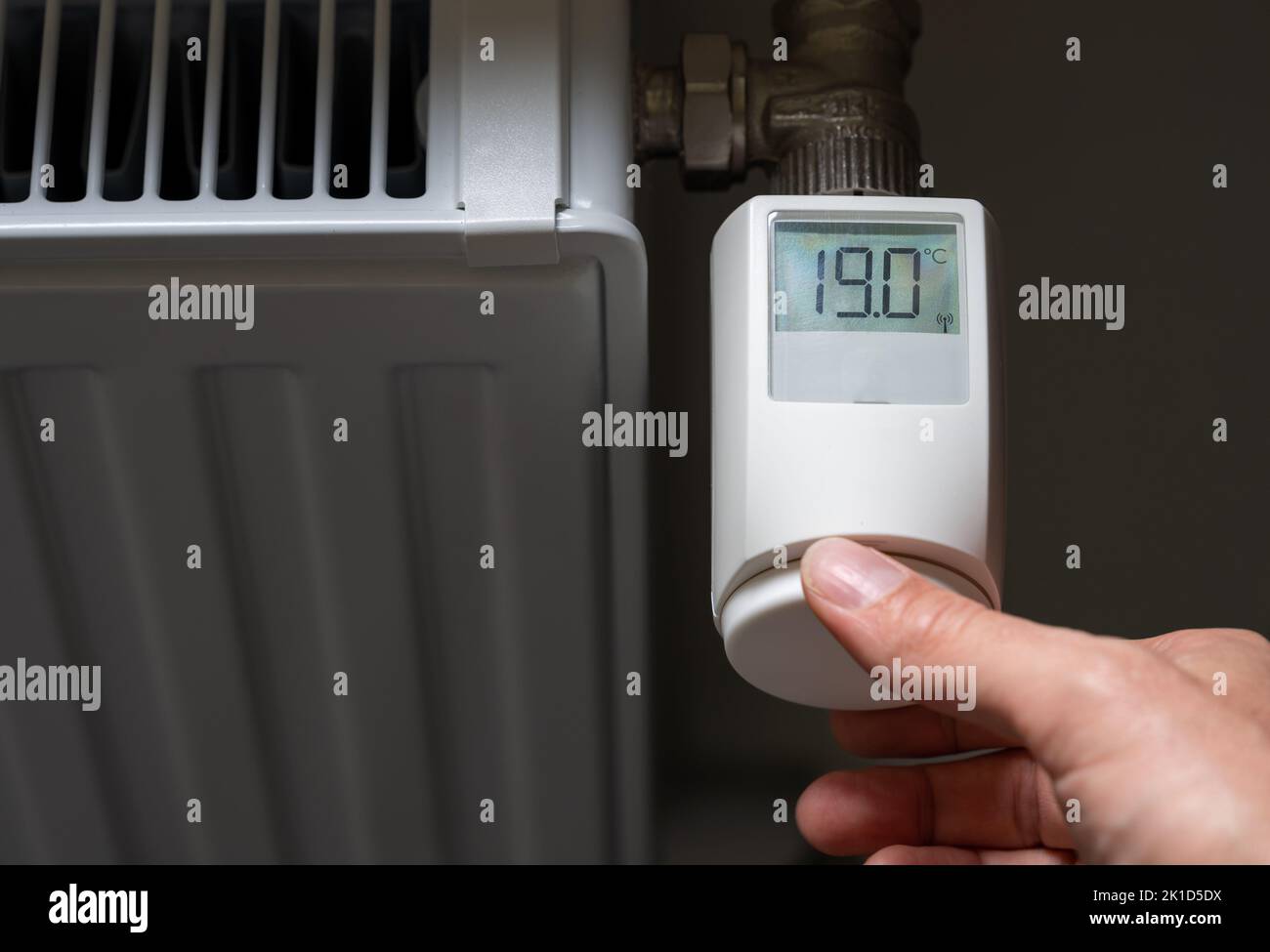 La commande manuelle abaisse la température à 19 degrés Celsius sur un thermostat électronique. Symbole d'économie d'énergie. Banque D'Images