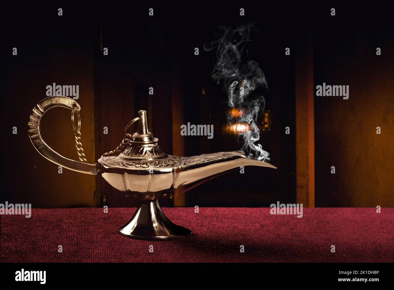 Une magie ancienne lampe sur un tableau de feutre rouge haut disperse un flot de fumée mystérieux. Banque D'Images
