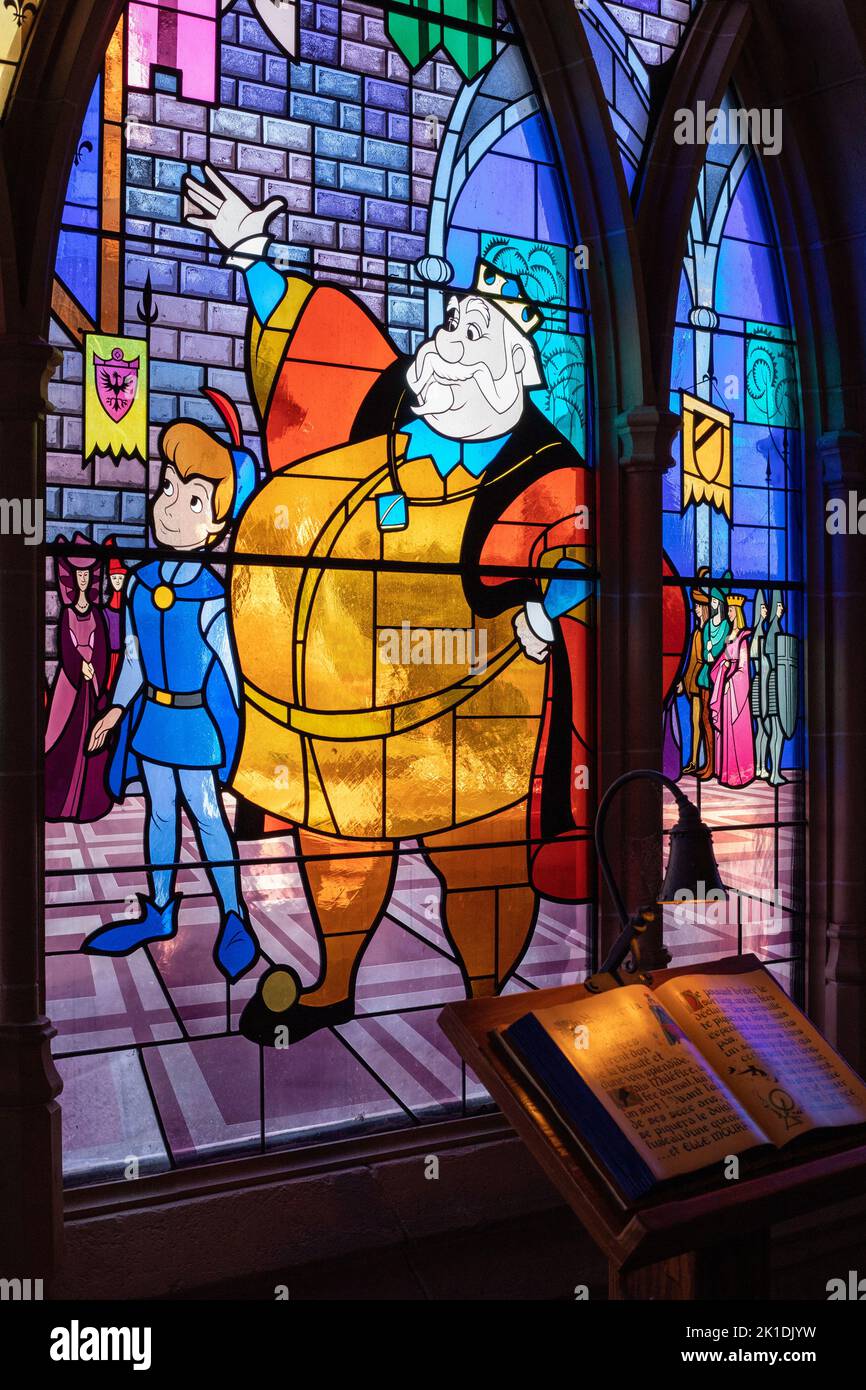 Photo verticale d'un vitrail coloré avec personnages de dessins animés Disney dans un parc à thème en France Banque D'Images