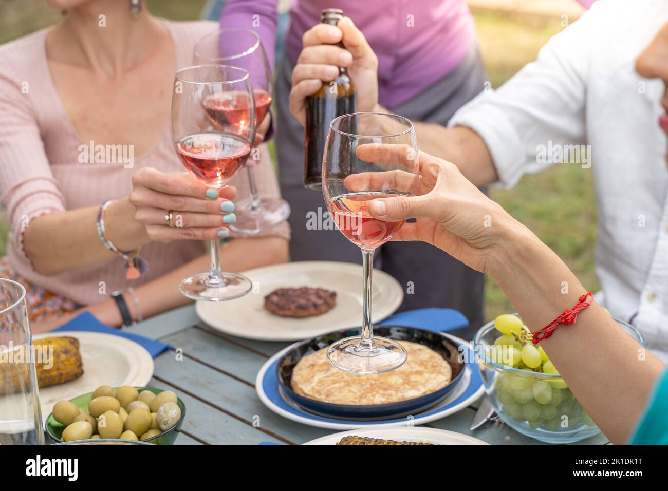 Gros plan d'un toast avec verres à vin rouge. Belles couleurs mains et lumière. Banque D'Images
