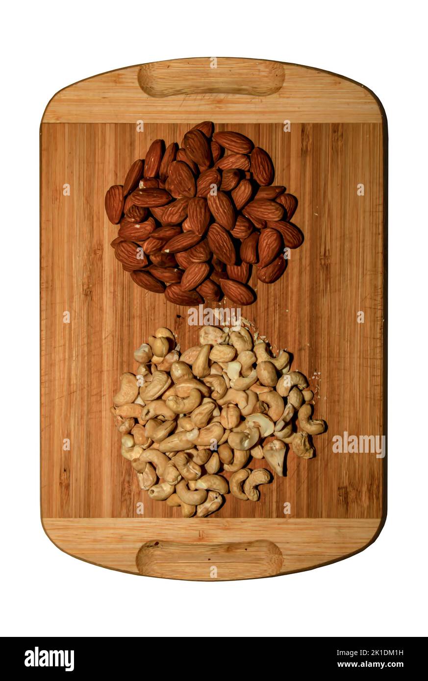 Fond naturel d'un mélange d'amandes et de noix de cajou. Isolé sur une planche de bois sur blanc. Concept d'alimentation saine. Banque D'Images