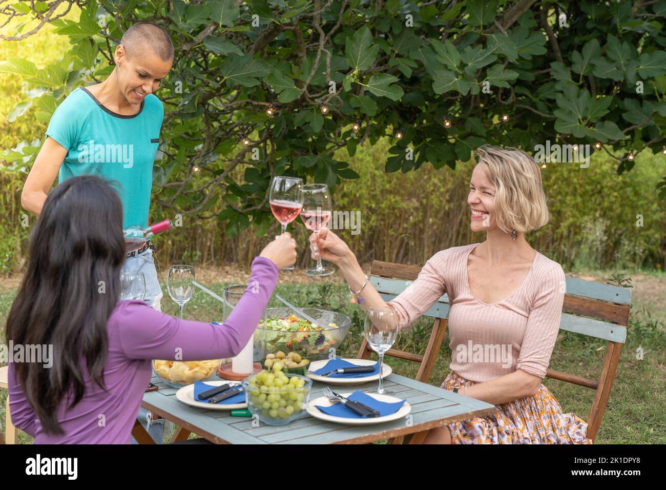 Groupe d'amis de femmes qui toaster autour de la table concept joyeux. Banque D'Images