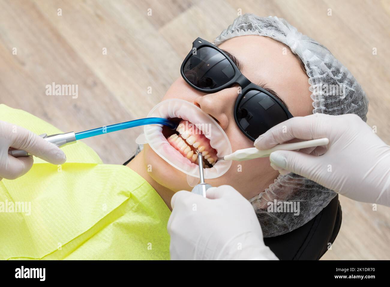 Patient avec enrouleur de joue allongé dans le cabinet du dentiste Banque D'Images Patient avec enrouleur de joue allongé dans le cabinet du dentiste Banque D'Images