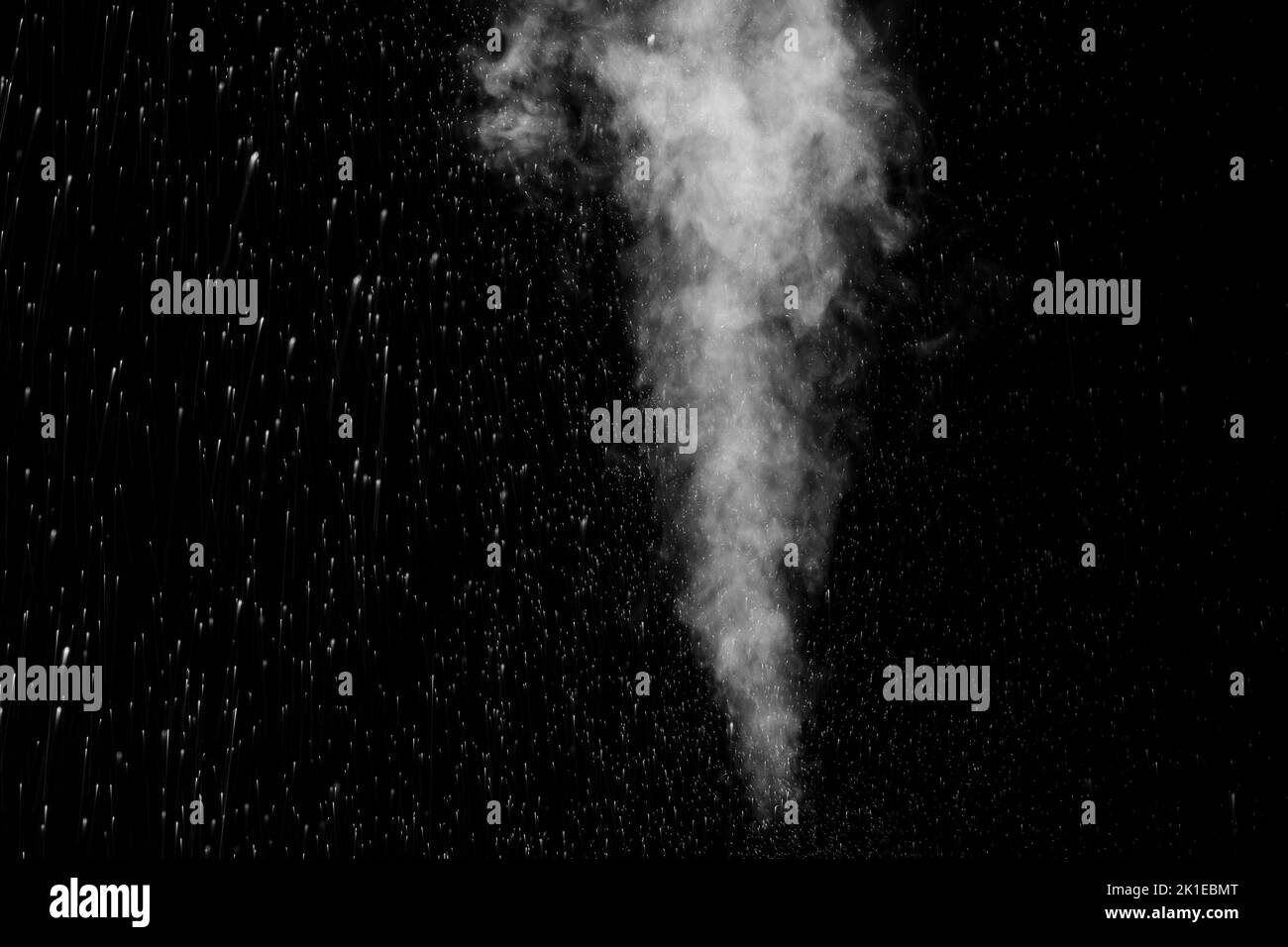 Vapeur blanche bouclés qui s'élève et projection d'eau dans différentes directions isolée sur fond noir. Évaporation du liquide et du condensateur Banque D'Images