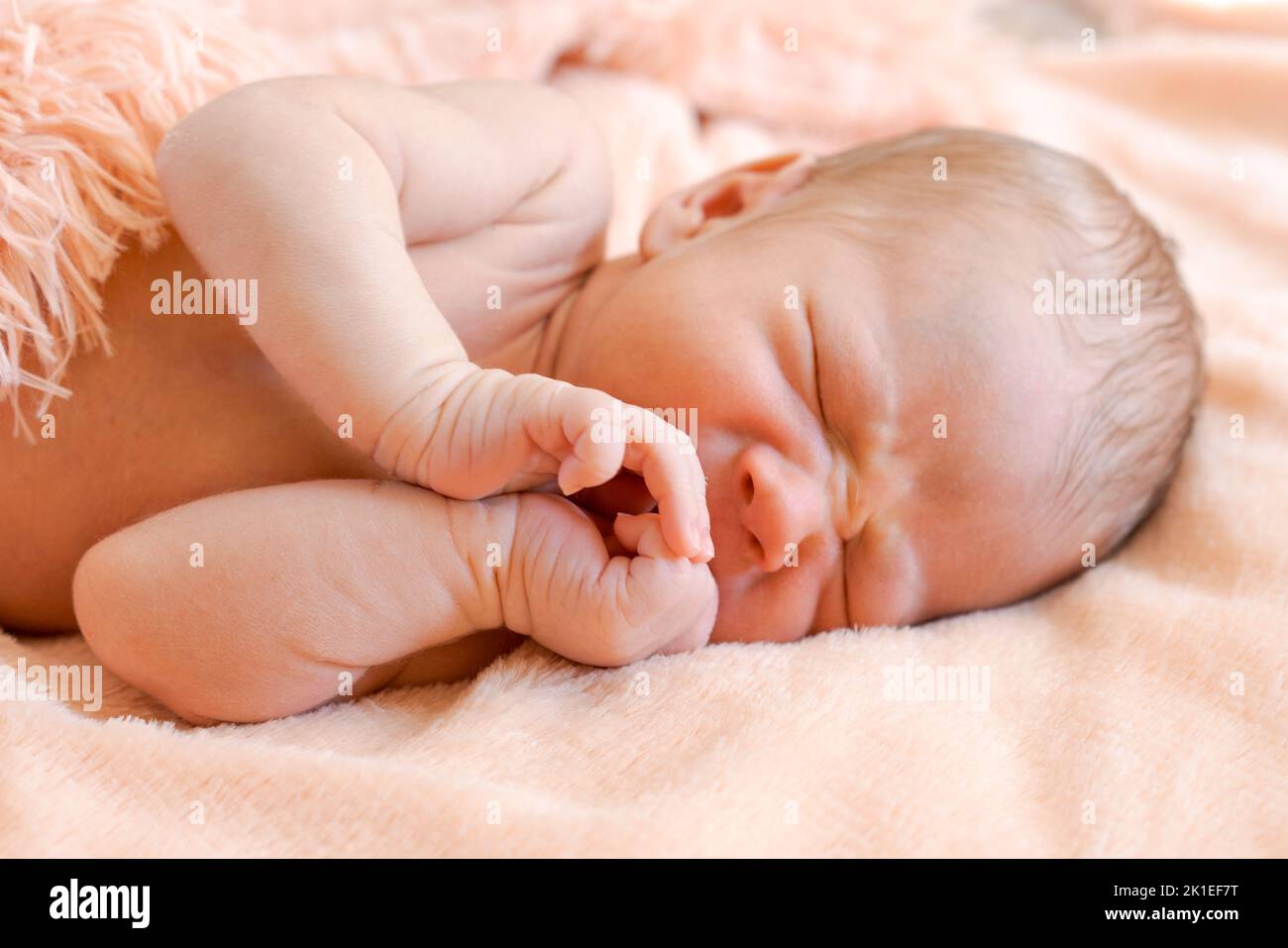 Un bébé mignon dort sur un couvre-lit rose moelleux, un bébé sain et mignon dort doucement dans les premiers jours de la vie Banque D'Images