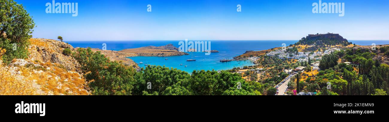 Vue panoramique sur le port coloré du village de Lindos et de l'Acropole, Rhodes. Vue aérienne du paysage magnifique, des ruines antiques, de la mer avec des voiliers et de la côte de l'île de Rhodes en mer Egée Banque D'Images