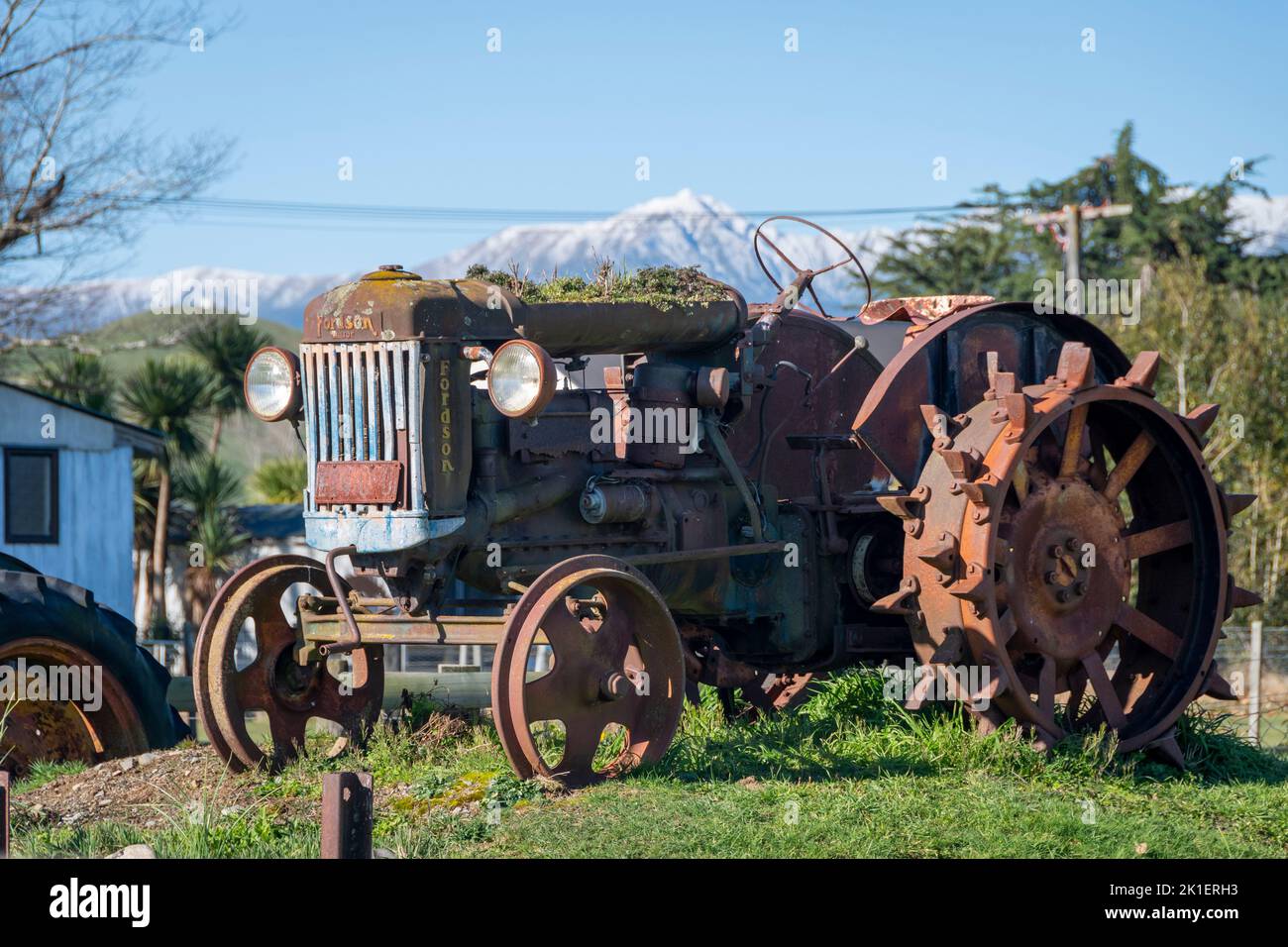 Tracteur d'époque, Apiti, Manawatu, Île du Nord, Nouvelle-Zélande. Chaîne de montagnes de Ruahine enneigées à distance. Banque D'Images