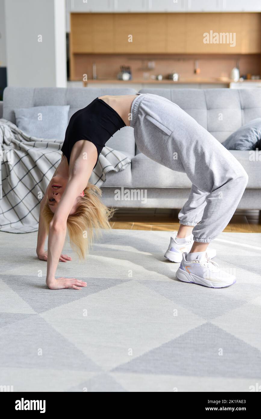 La femme effectue un exercice de pont à la maison Banque D'Images