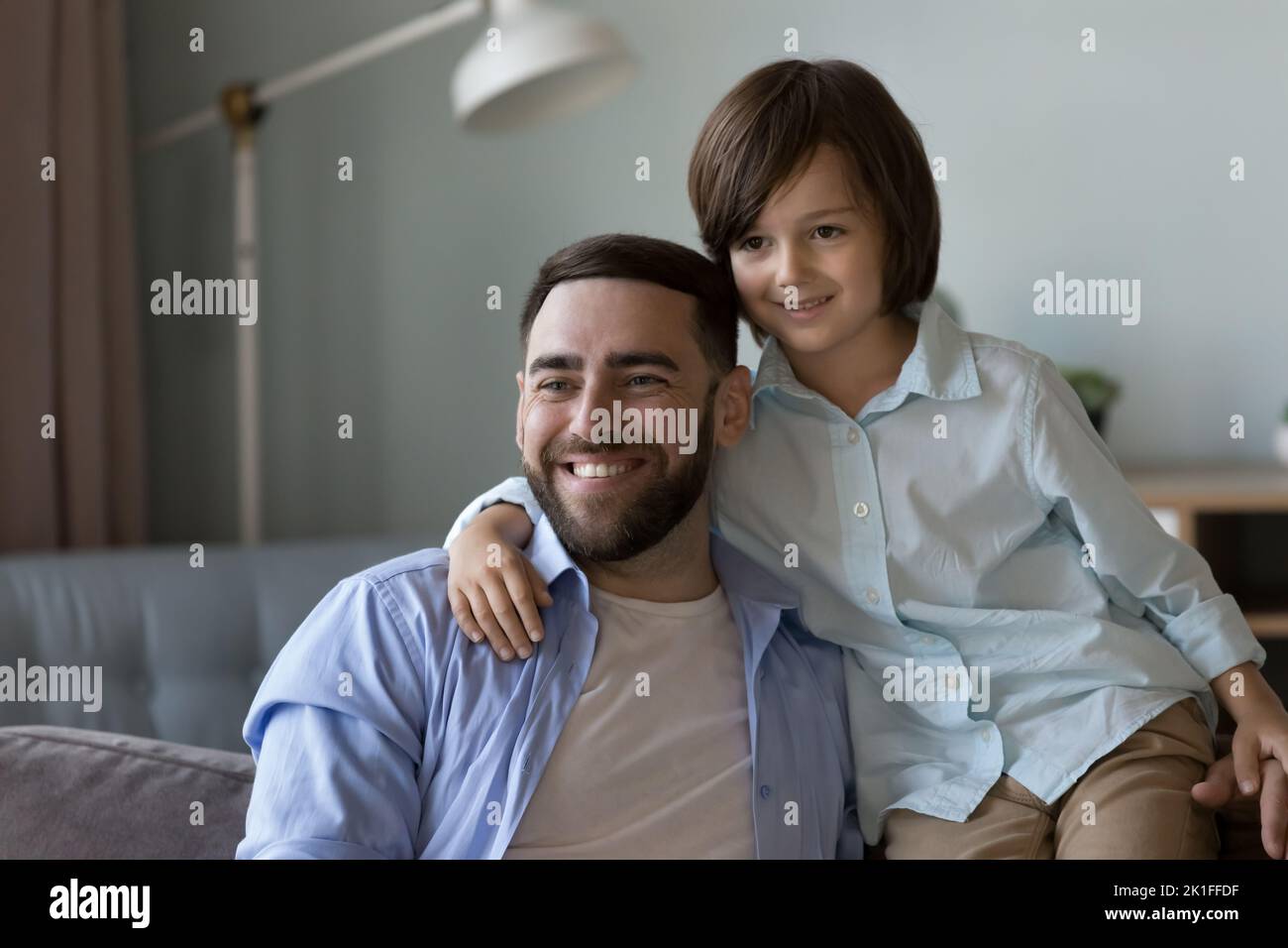 Un papa heureux et un petit fils qui s'amuse sur un canapé à la maison Banque D'Images
