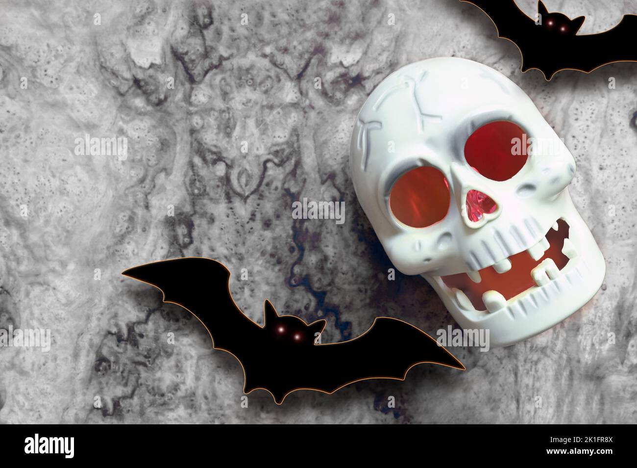 Crâne Halloween et décorations sur fond gris. Poser les battes et le crâne à plat. Carte de voeux pour Halloween Banque D'Images